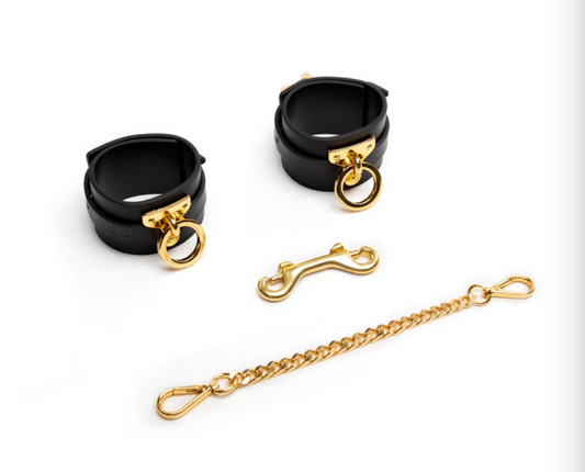 A pair of black bondage handcuffs with a chain link connection